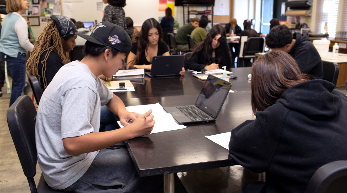 Students sitting at desks with laptops.