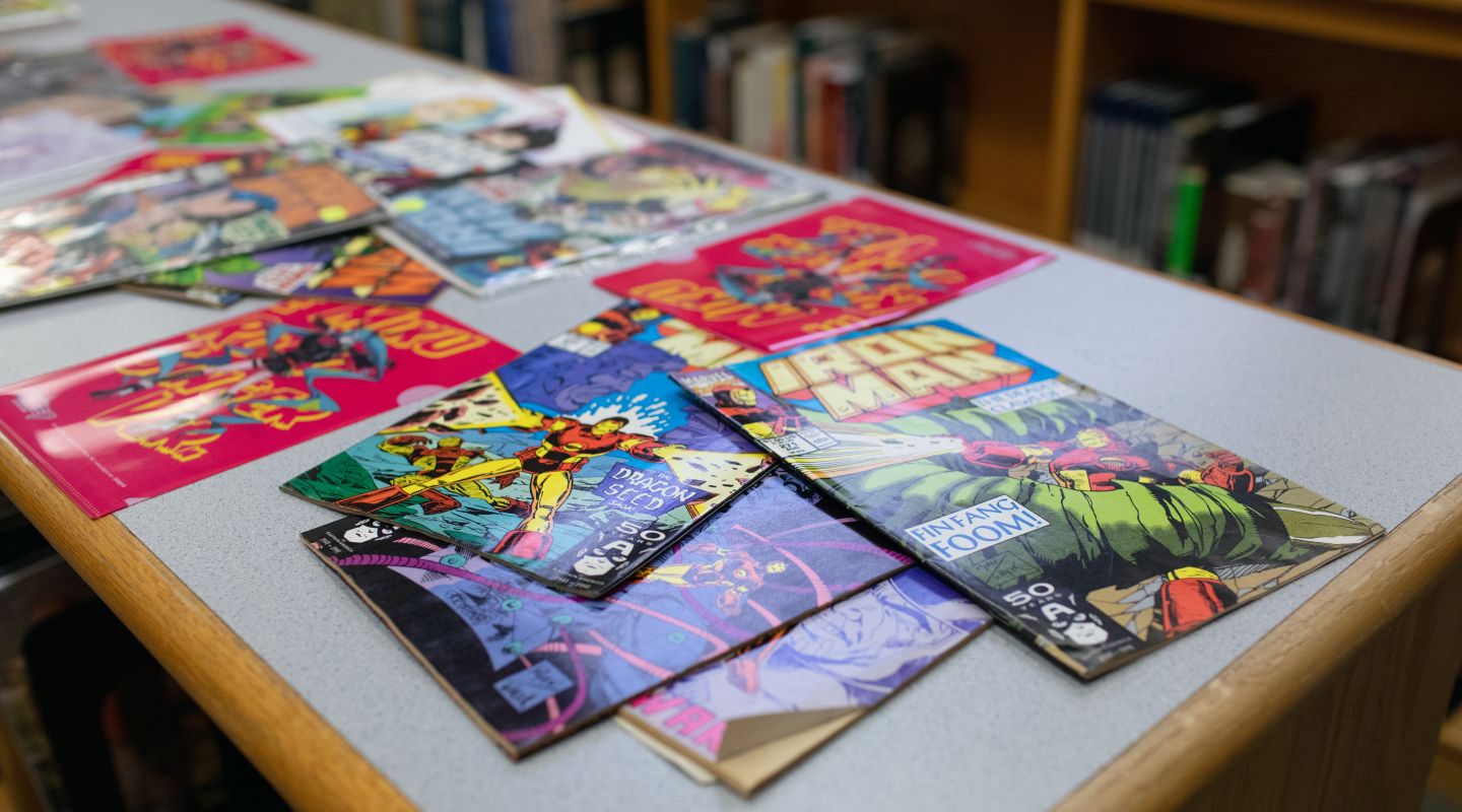 An image of various colorful comic book spread out across a table