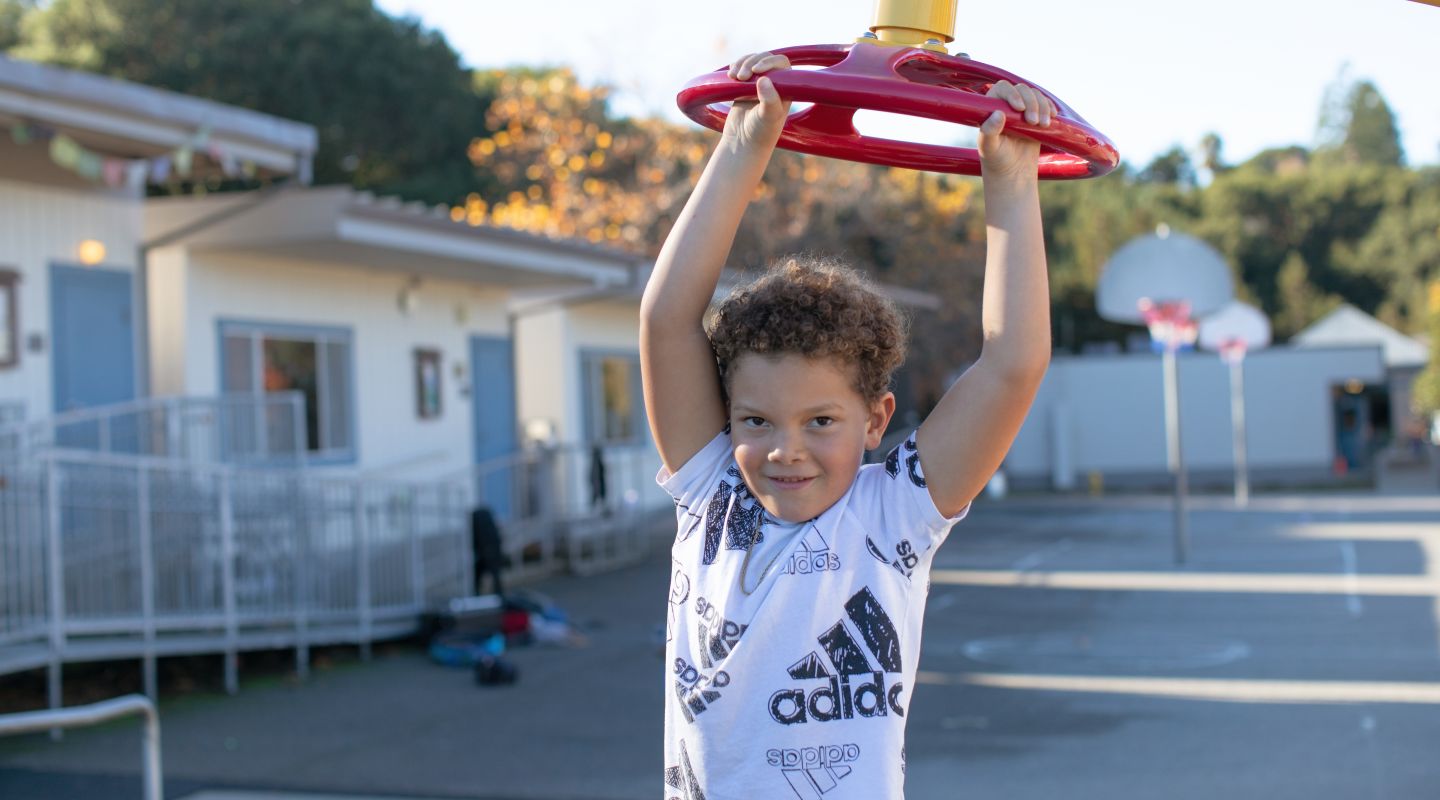 A student playing on playground equipment.