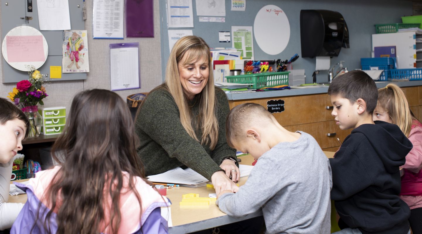 Penngrove Elementary students completing work at a desk with a teacher helping them