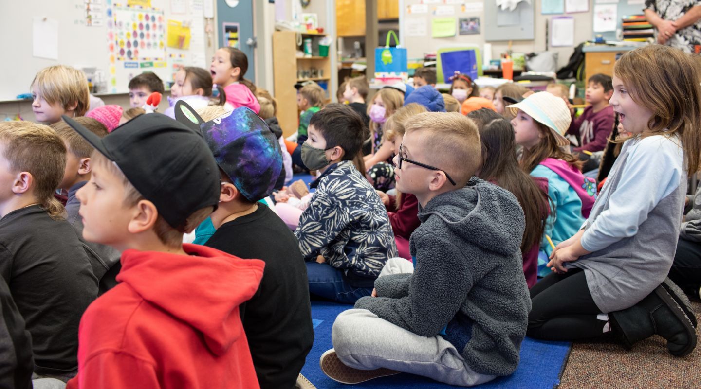 Penngrove students sitting on a rug, all looking to the front of the class